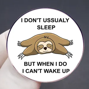 Cartoon sloth enamel pin with I Don't Usually Sleep text on round alloy badge