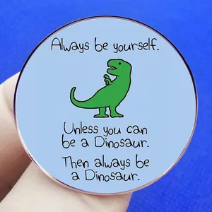 Broche dinosaure ronde avec citation 'Always be yourself' sur fond bleu texture