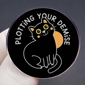 Funny black cat enamel pin with 'Plotting Your Demise' text and orange background