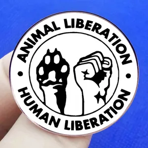 Insigne rond en métal Animal Liberation et Human Liberation sur fond bleu texturé