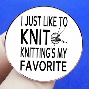 Round metal badge featuring 'I Just Like To Knit' text and yarn ball graphic on blue fabric