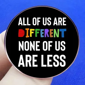 Black round badge with 'All of us are different' text, held against blue background