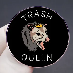 Cartoon Opossum Queen enamel pin featuring Trash Queen slogan on a round black badge