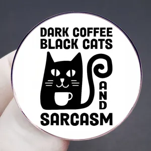 Schwarze Katze Kaffee und Sarkasmus Emaille-Pin, runder Button in der Hand gehalten