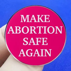 Make Abortion Safe Again brooch featuring bold white text on a pink round badge