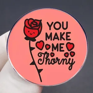 Pink round enamel pin with cute cartoon rose and heart, featuring You Make Me Thorny text