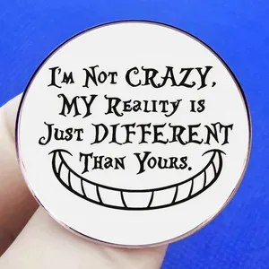 Cheshire Cat badge with I'm Not Crazy quote on a round white metal enamel pin
