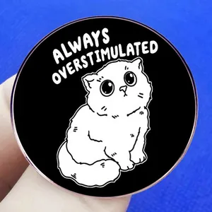 Humorous cartoon cat pin badge with 'Always Overstimulated' text on black alloy metal