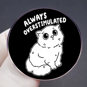 Funny cartoon cat badge with Always Overstimulated text on black metal brooch