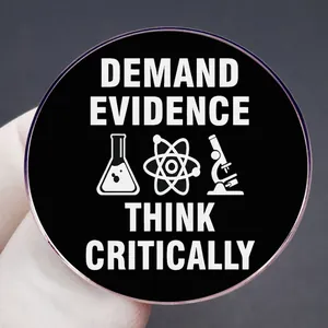 Black round enamel pin with Demand Evidence Think Critically text and science icons