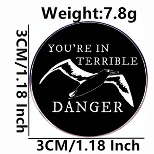 Enamel seagull pin featuring You're In Terrible Danger text in a 3cm round black badge