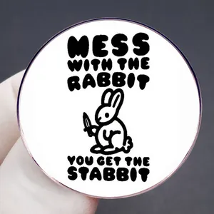 Round pin with cartoon rabbit holding a knife and funny quote Mess with the rabbit