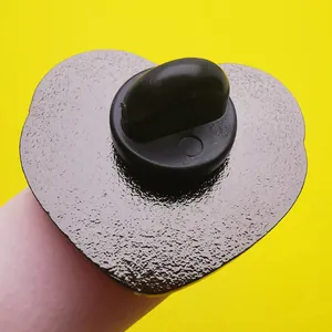 Dettaglio macro del retro della spilla a forma di cuore con finitura opaca e chiusura nera
