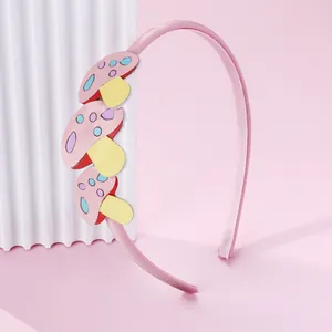 Détail d'un serre-tête rose pour enfant avec motifs champignons et dents intérieures antidérapantes