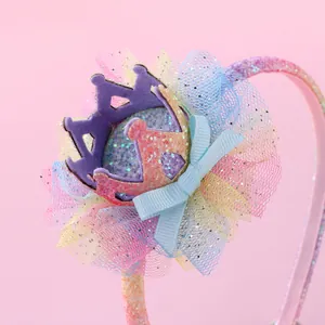 Détail de couronne de princesse à paillettes avec tulle arc-en-ciel et nœud bleu sur serre-tête