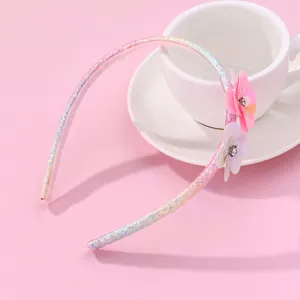 Pink sequin flower headband for girls with sparkling rhinestones on a soft pink background