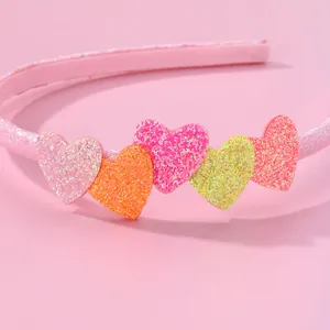 Pink heart headband for girls with five colorful glitter heart ornaments on pink background
