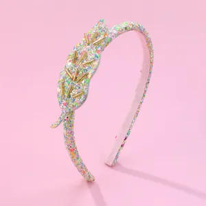 Détail d'un serre-tête à feuilles pailletées avec des sequins brillants et perles dorées