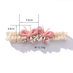 Bandeau bébé en dentelle avec papillons en tissu floral rose et détail de largeur