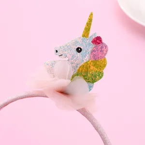 Cute kids unicorn headband with pink sequins and rainbow mane on a soft pink background