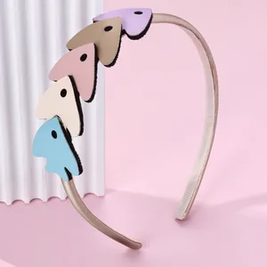 Détail de cœurs colorés en cuir PU sur un serre-tête doré pour filles