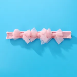Bandeau élastique rose pour bébé avec trois nœuds en maille sur fond bleu vif