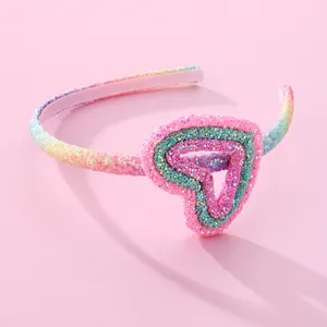 Rainbow sequin headband for girls with a sparkling heart ornament on pink background
