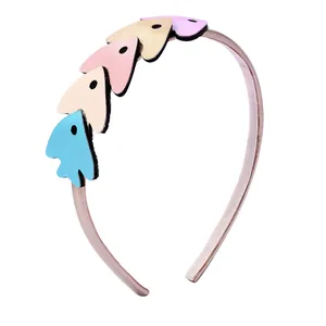 Détail du serre-tête en tissu rose avec cinq pendentifs flèches colorés en similicuir