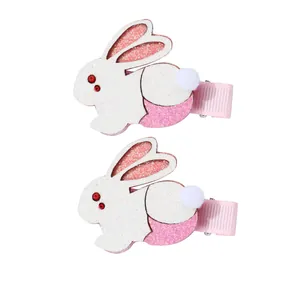 Pair of cute glitter bunny hair clips for girls featuring white and pink fabric with pompoms