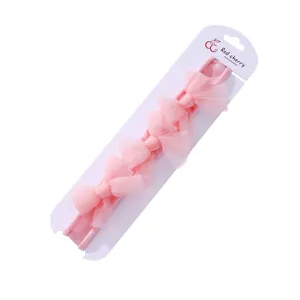 Bandeau rose pour bébé avec cinq nœuds en maille sur un élastique souple