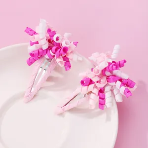 Paar bunte Haarspangen mit spiralförmigem Band und rosa Entenschnabelklemmen auf Keramik