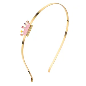 Detailansicht eines goldenen Haarreifs mit rosa Kronenanhänger und bunten Punkten