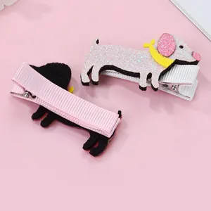 Detail of cartoon puppy hair clips with pink glitter surface and soft velvet backing