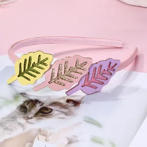 Détail de feuilles à paillettes scintillantes jaunes, roses et mauves sur un serre-tête