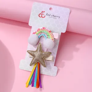 Rainbow and star hair clip set for kids with glitter and ribbons on a pink card