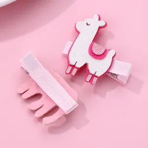 Detail of pink alpaca hair clips showing glitter finish and fabric-wrapped metal base
