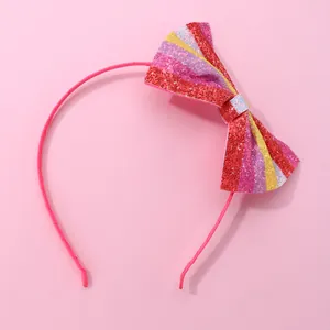 Detail of glittery colorful sequin bow headband for girls on a soft pink background
