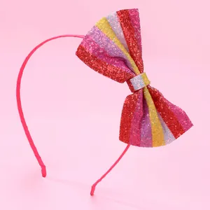 Detail of pink children's headband featuring a large glittery striped sequin bow
