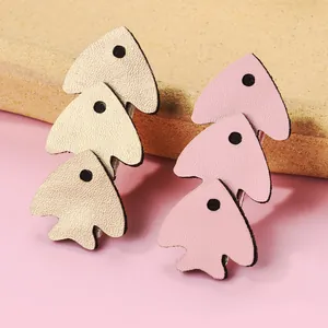 Close-up of pink and gold fish-shaped PU leather hair clips with textured finish