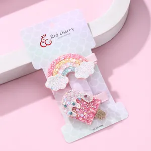 Détail de barrettes pailletées arc-en-ciel et crème glacée sur carton blanc