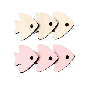 Detailed view of layered fish hair clips in gold and pink textured synthetic leather
