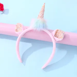 Pink plush unicorn headband with glitter horn and rainbow pom-poms for girls