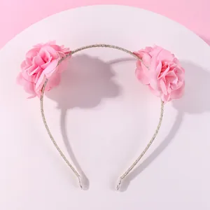 Serre-tête fleuri avec deux fleurs en tissu rose sur un bandeau argenté étincelant