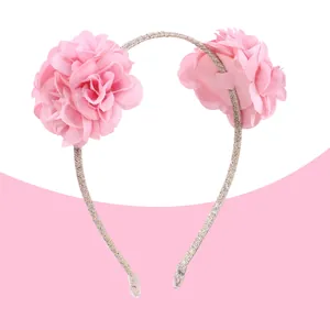 Détail d'un serre-tête à fleurs roses en tissu avec paillettes argentées et embouts doux