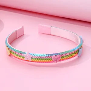 Rainbow sequin children headband with glitter star and heart charms on pink background