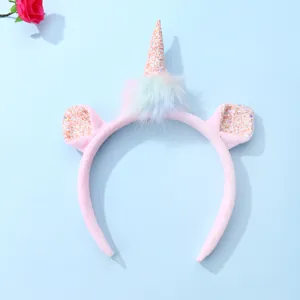 Detail of plush pink unicorn headband with glittering horn and colorful faux fur accent