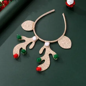Christmas reindeer antler headband with gold glitter and colorful pom-poms on green background