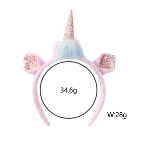 Detail of pink plush unicorn headband featuring colorful pompoms and shiny sequin horn