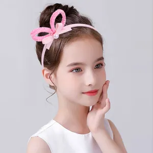 Détail d'un serre-tête rose avec oreilles de lapin pailletées et perle pour filles