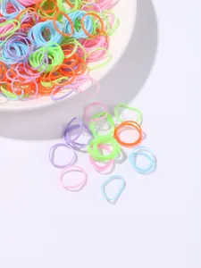 Close-up of colorful elastic hair bands in vibrant macaron shades on a white tray